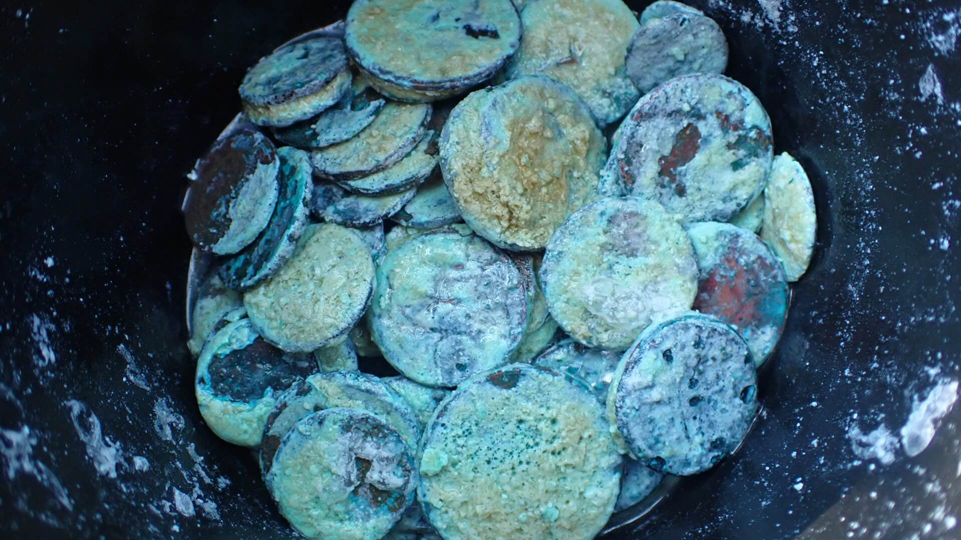 Cleaning copper coins in soapy water